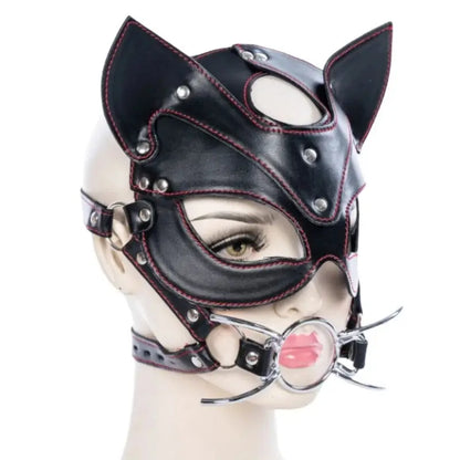 Máscara BDSM estilo gato con ball gag metálico, cuero sintético negro y correas ajustables. Accesorio erótico de la marca Shakti Energy.